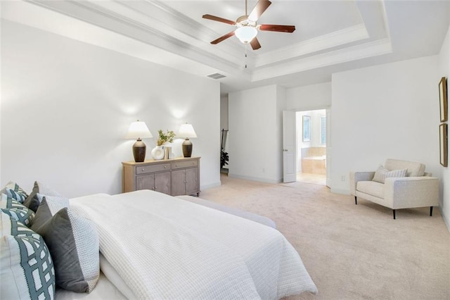 bedroom with ensuite bathroom, light carpet, ceiling fan, a tray ceiling, and crown molding