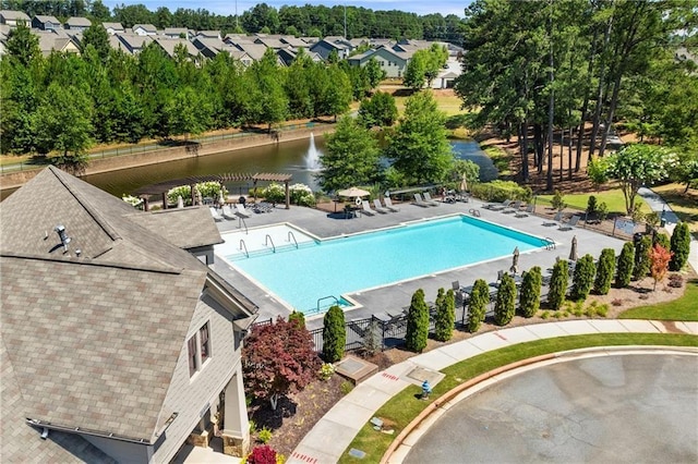 view of pool featuring a patio area, a pergola, and a water view