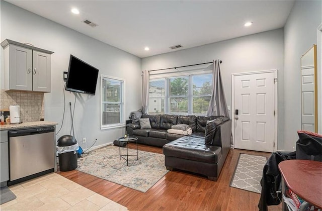 living area with light wood-style flooring, visible vents, and recessed lighting