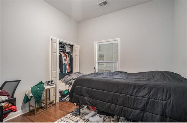 bedroom featuring wood finished floors, visible vents, and baseboards