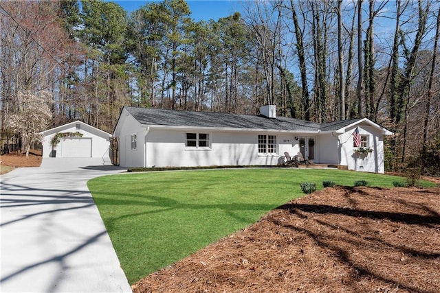 ranch-style house featuring an outbuilding, a front lawn, concrete driveway, a garage, and a chimney