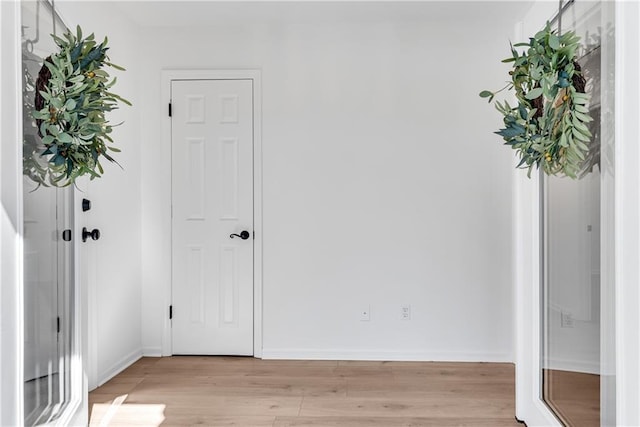 foyer featuring baseboards and light wood-style floors