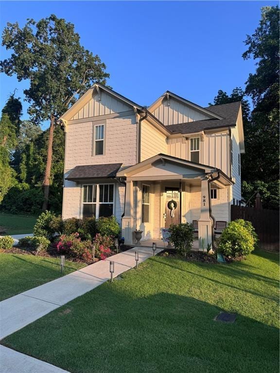 view of front facade featuring board and batten siding, covered porch, and a front lawn