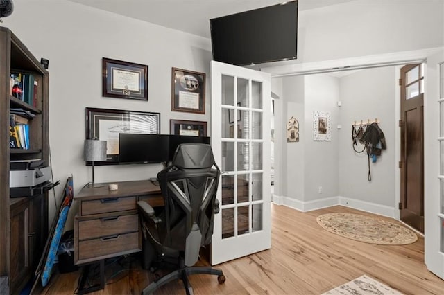 office area featuring french doors, light wood finished floors, and baseboards