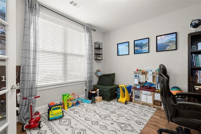 home office featuring visible vents, baseboards, and wood finished floors