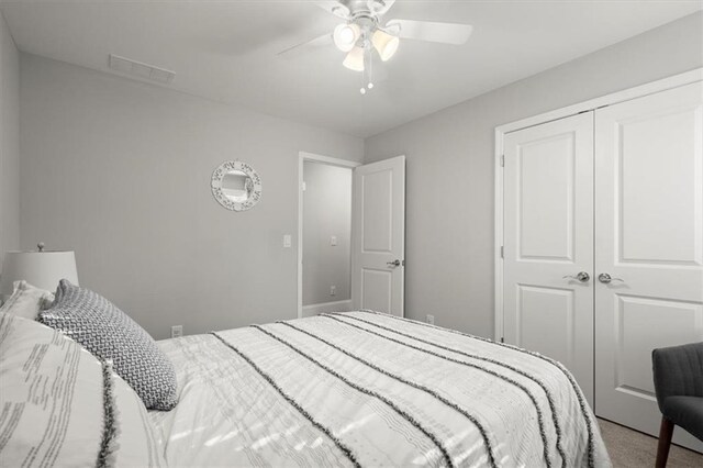 bedroom featuring carpet floors, a closet, visible vents, and ceiling fan