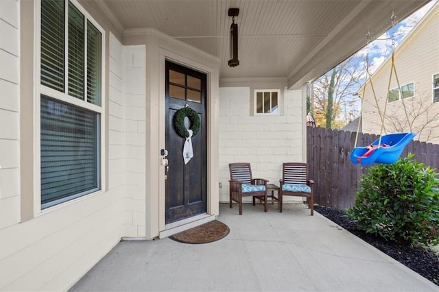 property entrance featuring concrete block siding and fence