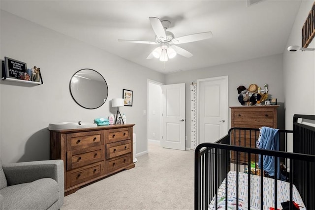 bedroom with light carpet, ceiling fan, and baseboards