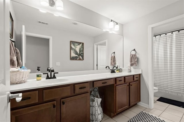 full bath featuring toilet, a sink, visible vents, tile patterned floors, and double vanity