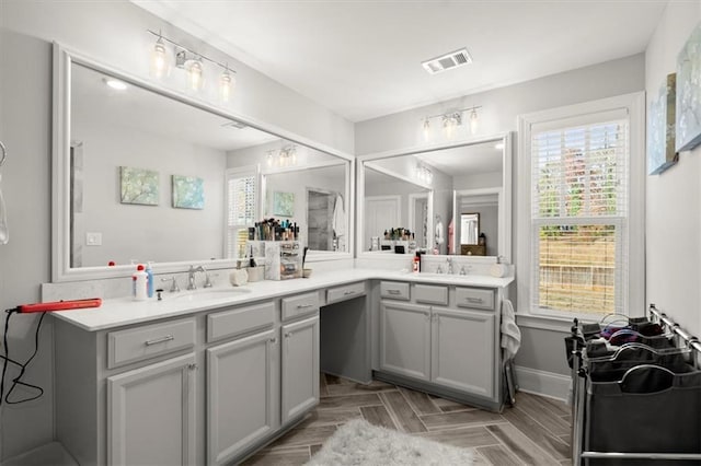 bathroom featuring baseboards, visible vents, and vanity