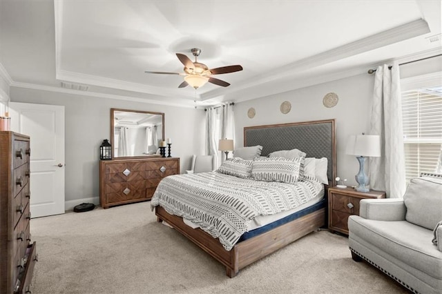 bedroom with a tray ceiling, visible vents, ornamental molding, light carpet, and baseboards