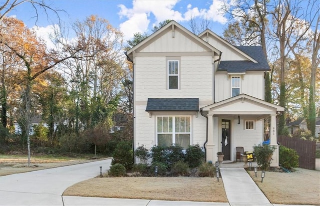 view of front of home featuring fence, board and batten siding, and roof with shingles