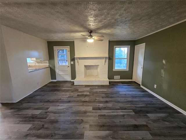 unfurnished living room featuring ceiling fan, dark wood-type flooring, a fireplace, and a textured ceiling