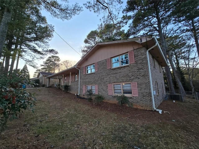 property exterior at dusk featuring a lawn