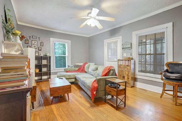 sitting room featuring ceiling fan, a textured ceiling, light hardwood / wood-style floors, and crown molding