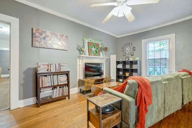 living room featuring ornamental molding, wood-type flooring, and ceiling fan