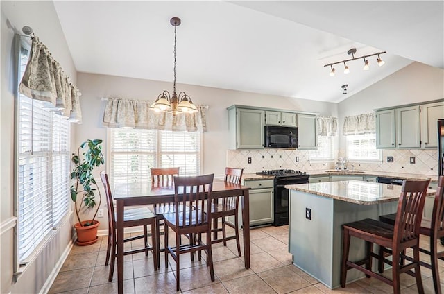 kitchen with a sink, black appliances, vaulted ceiling, backsplash, and a center island