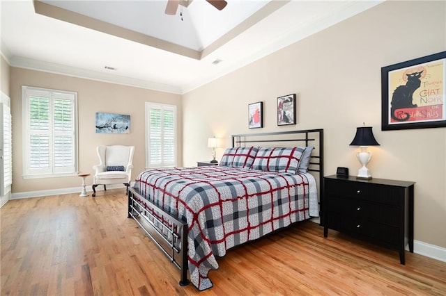 bedroom with baseboards, visible vents, light wood-style floors, and ornamental molding