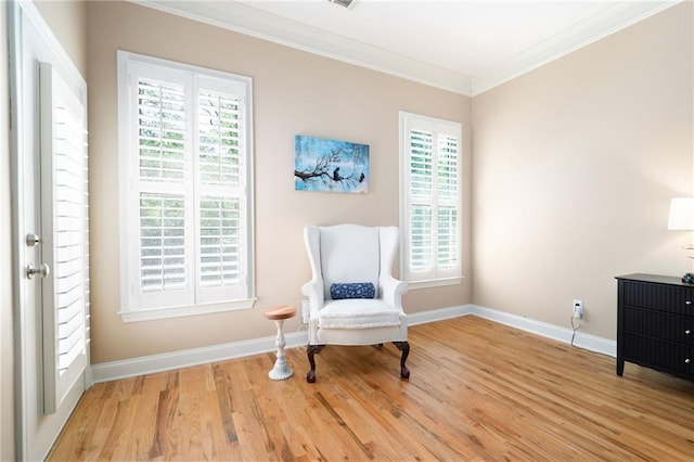 living area with baseboards, crown molding, and wood finished floors