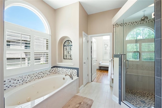 bathroom with tile patterned floors, baseboards, a whirlpool tub, and a stall shower