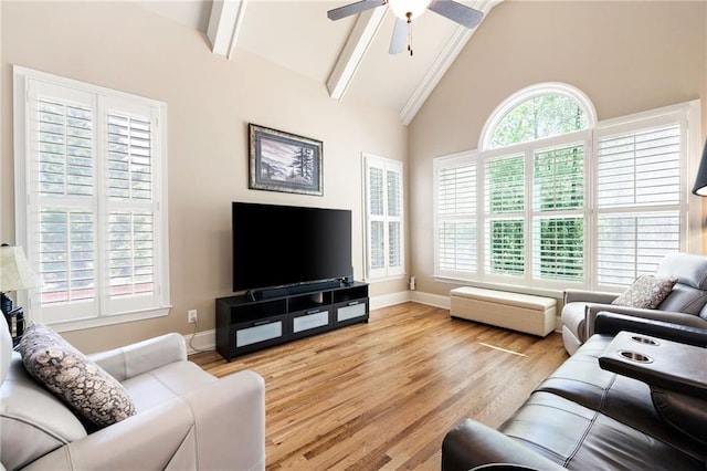 living room featuring light wood finished floors, a ceiling fan, beamed ceiling, baseboards, and high vaulted ceiling
