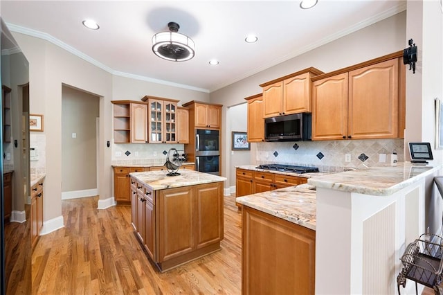 kitchen featuring stainless steel appliances, a peninsula, light wood-type flooring, backsplash, and glass insert cabinets