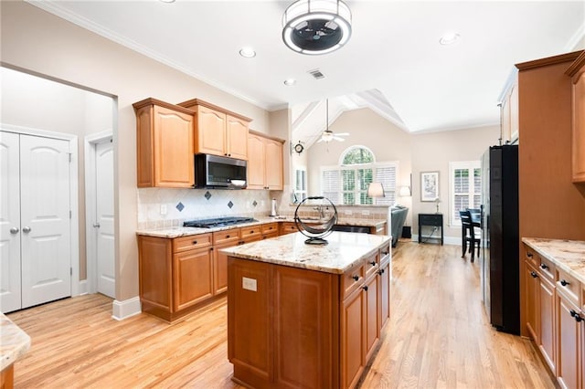 kitchen with visible vents, light wood-style floors, light stone countertops, appliances with stainless steel finishes, and ceiling fan