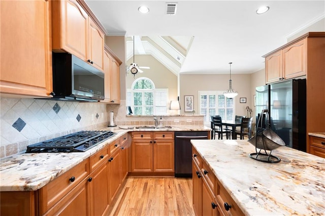 kitchen featuring black gas cooktop, a sink, freestanding refrigerator, dishwashing machine, and light stone counters