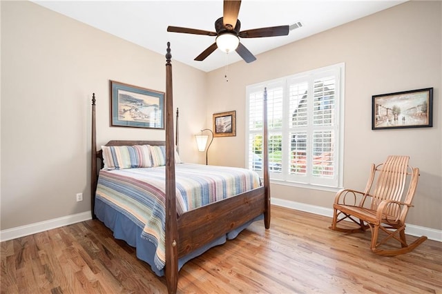 bedroom featuring light wood-type flooring, visible vents, baseboards, and ceiling fan