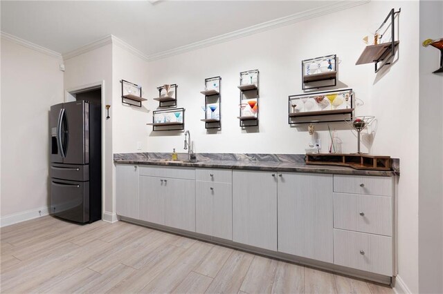 kitchen with dark countertops, fridge with ice dispenser, open shelves, and a sink