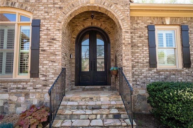 entrance to property featuring brick siding and french doors