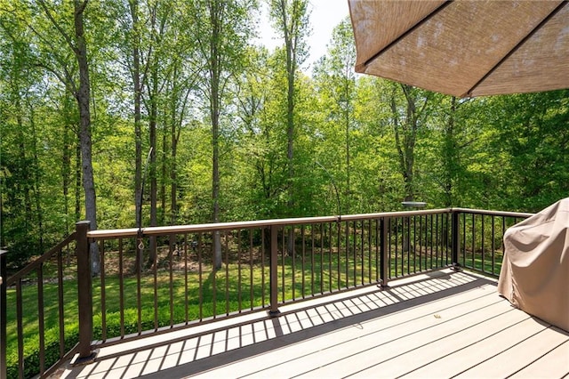 wooden terrace featuring a yard and a wooded view