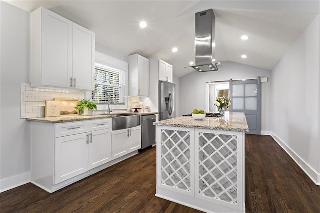 4178 Castle Pines Ct, Tucker, GA 30084 - kitchen featuring appliances with stainless steel finishes, wall chimney exhaust hood, lofted ceiling, a center island, and a barn door