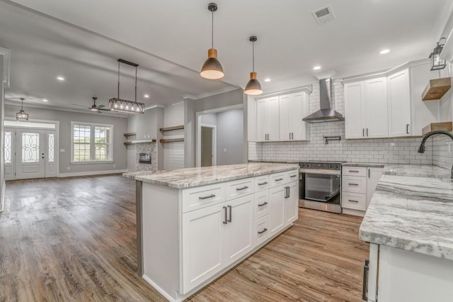 961 Goat Rd NW, Resaca, GA 30735 - kitchen featuring wall chimney exhaust hood, stainless steel electric range, light wood-type flooring, a center island, and backsplash