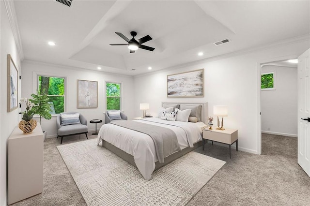 carpeted bedroom with a raised ceiling, ornamental molding, and ceiling fan