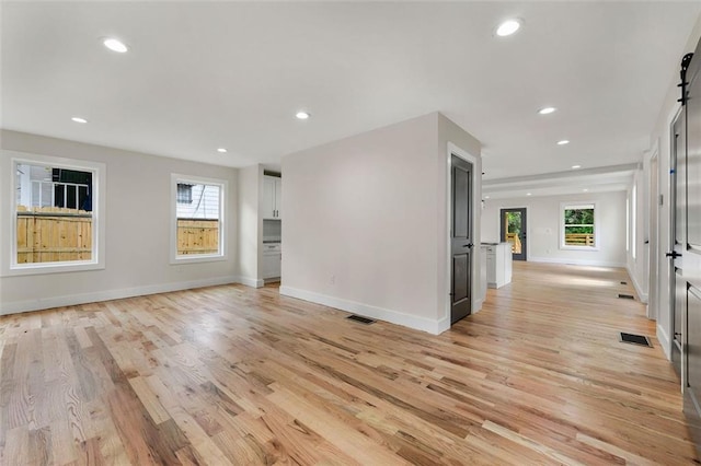 interior space with light wood-type flooring and a barn door