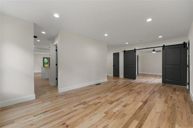 interior space with a barn door and light hardwood / wood-style flooring