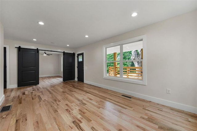 interior space featuring light hardwood / wood-style floors and a barn door