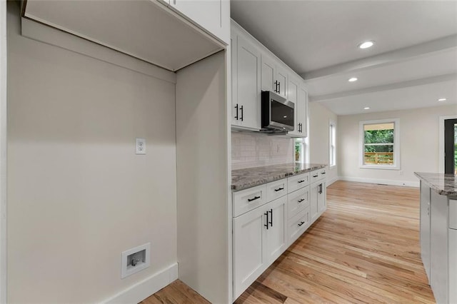 kitchen featuring light wood-type flooring, tasteful backsplash, light stone counters, and white cabinets