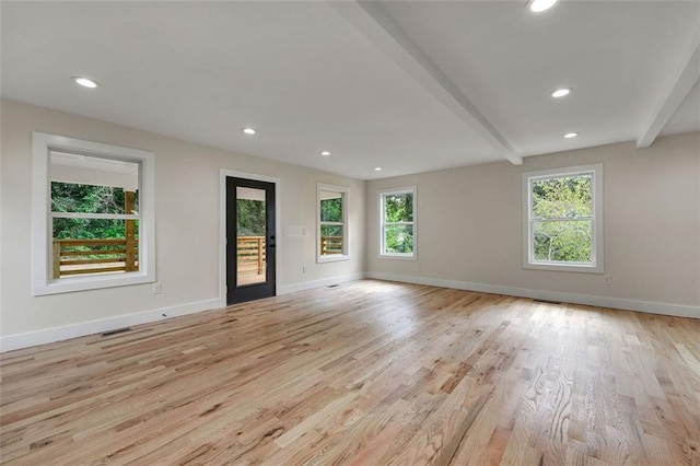 interior space with beam ceiling, light hardwood / wood-style floors, and a wealth of natural light