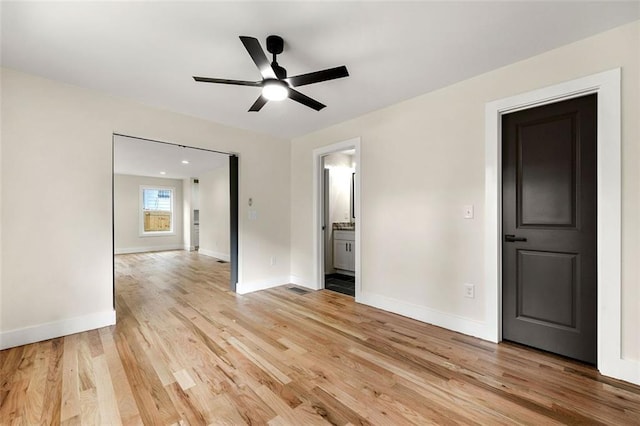 empty room with ceiling fan and light hardwood / wood-style flooring