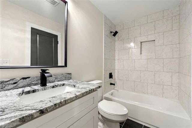 full bathroom featuring vanity, tiled shower / bath combo, toilet, and tile patterned floors