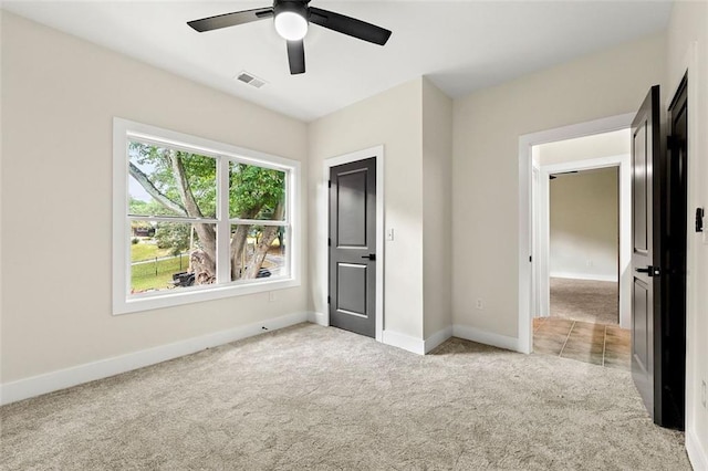 unfurnished bedroom with light carpet and ceiling fan