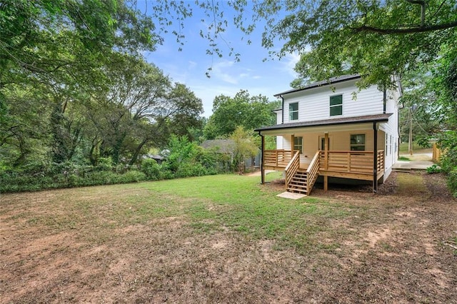 rear view of property featuring a lawn and a wooden deck