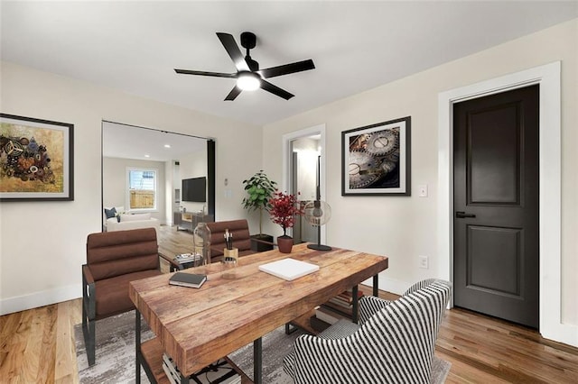 dining space with hardwood / wood-style floors and ceiling fan