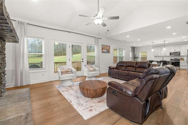 living area featuring lofted ceiling, a wealth of natural light, light wood-style flooring, and recessed lighting