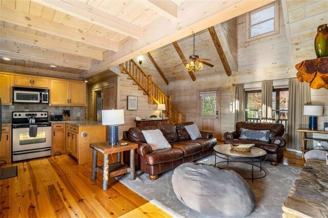 living room featuring ceiling fan, lofted ceiling with beams, wooden walls, wood ceiling, and hardwood / wood-style flooring