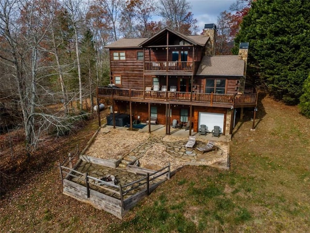 back of property with a balcony, a lawn, a patio area, and a wooden deck