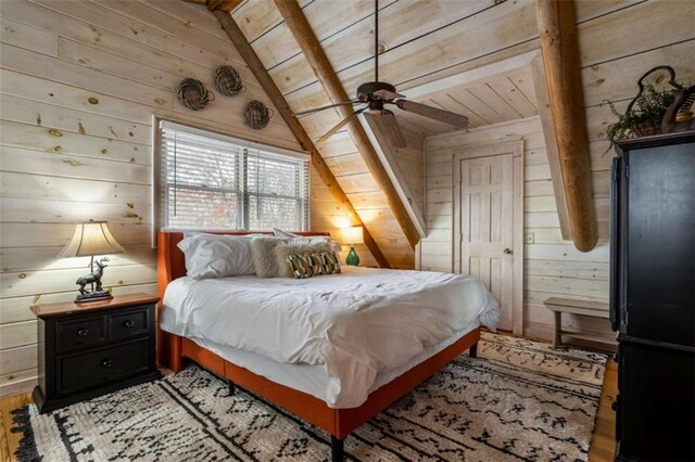 bedroom with ceiling fan, light hardwood / wood-style flooring, wooden walls, and vaulted ceiling