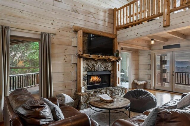 living room with hardwood / wood-style floors, wood walls, and a fireplace